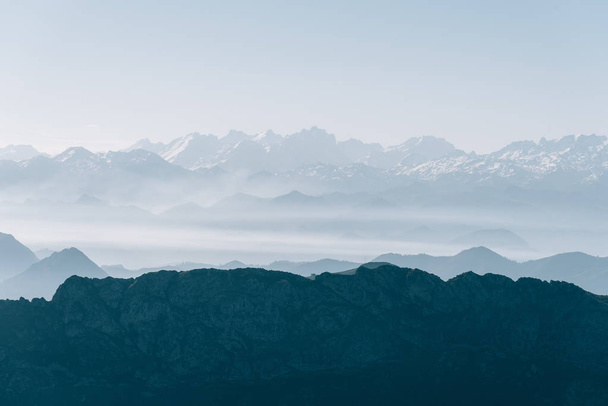 Scenic näkymä siluetit vuorten aamulla sumu
 - Valokuva, kuva