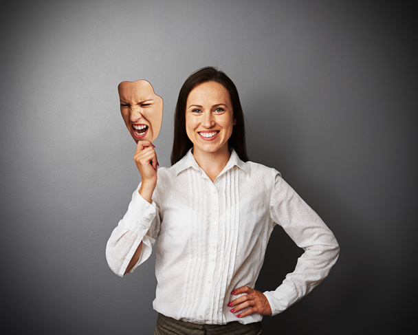 женщина держит сумасшедшую маску
 - Фото, изображение