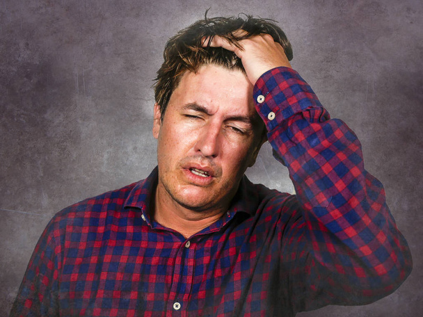 stressed white man holding head with hands in crazy stress and frustrated face expression looking to camera having problem isolated on grunge background - Photo, Image