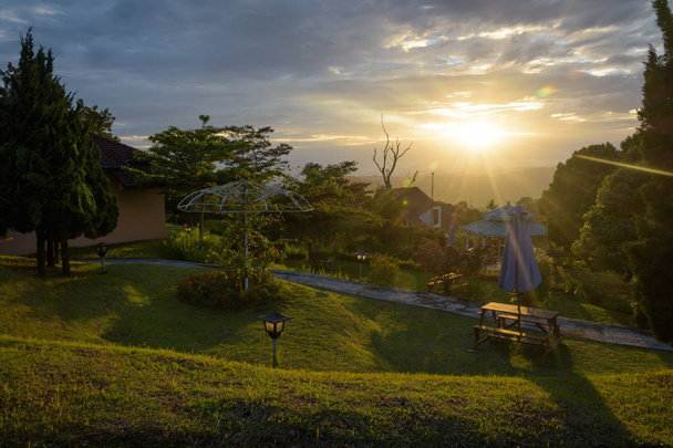 Захватывающая сцена восхода или заката солнца на заднем дворе отеля и курорта Фалфаан Хиллз на индонезийском острове Семаранг. Теплым утром в саду
. - Фото, изображение