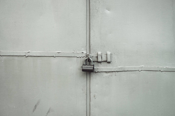Karkea metalli portti lukko lähikuva. Grunge tausta metallinen ovi riippulukko. Lukittu portti ja kopiotila. Harmaa rakenne likainen teollinen seinä lukittu sisäänkäynti. Yksityinen omaisuus suojattu
. - Valokuva, kuva