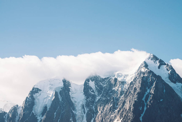 Geweldige gletsjer onder de blauwe hemel. Bergketen met sneeuw. Enorme wolk op gigantische prachtige besneeuwde bergen. Sfeervolle minimalistische Moody landschap van majestueuze natuur van de hooglanden in matte tinten. - Foto, afbeelding