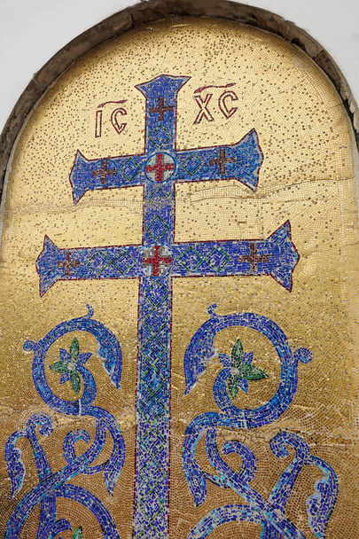 Az ortodox kereszt mozaikképe a növényzet elemeivel. Kék kereszt arany háttérrel - Fotó, kép