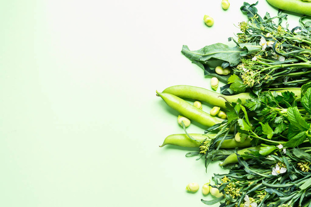 Green vegetables and herbs on pastel background - Photo, Image