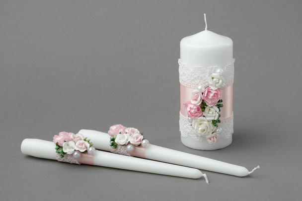 Three candles decorated with beautiful roses, pearls, pink silk ribbons and lace. - Foto, imagen