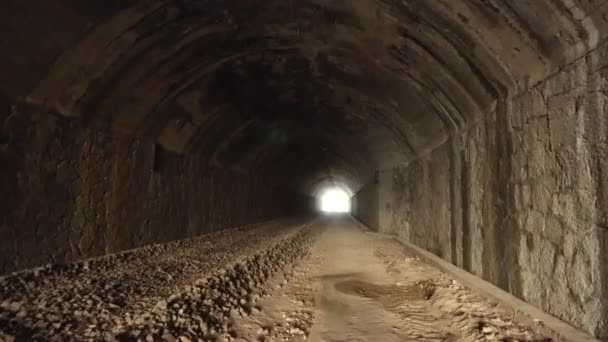 POV séta belül a régi, sötét, hosszú elhagyott alagút, erős fény a végén. - Felvétel, videó