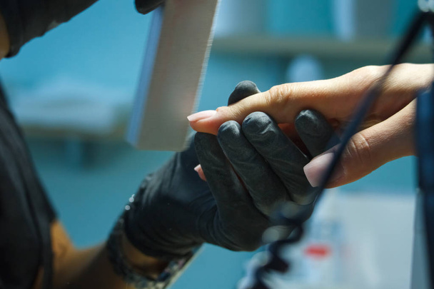 Nahaufnahme Maniküre Hände machen weibliche Maniküre im Nagelstudio. - Foto, Bild