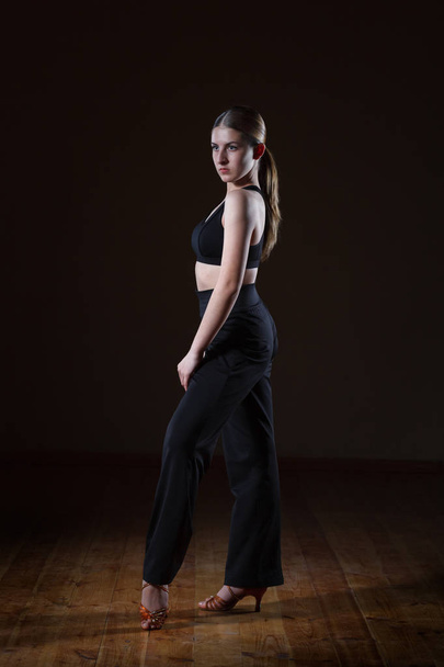 beautiful girl wearing black sportswear is training in the dance - Fotografie, Obrázek
