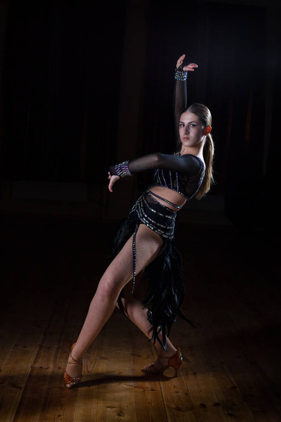 Красива латино дівчина танцівниці в елегантній чорної сукні на чорному Баку - Фото, зображення