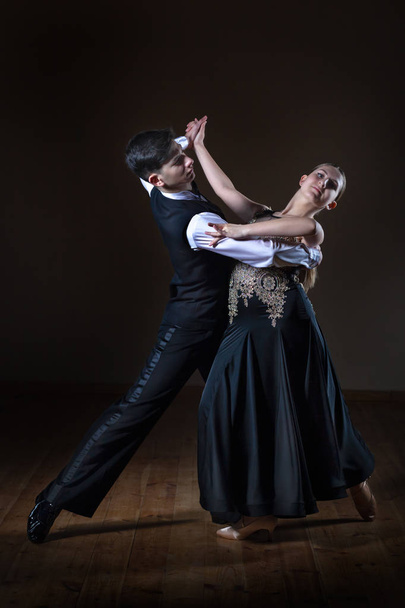 Beaux jeunes danseurs dans la salle de bal isolés sur fond noir
 - Photo, image