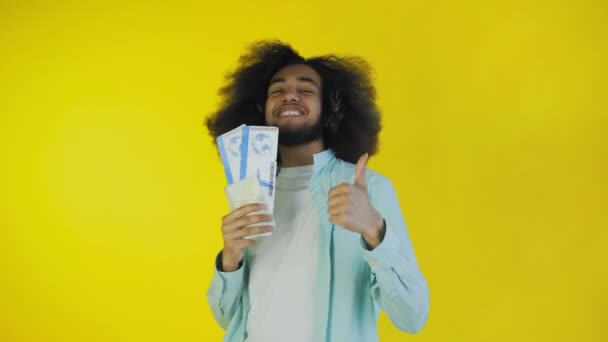 Young Afro-American man with boarding pass tickets on yellow background. - Footage, Video