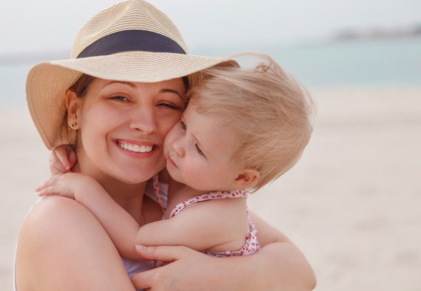 Portrait of mother holding her bay girl at beach - Foto, Bild