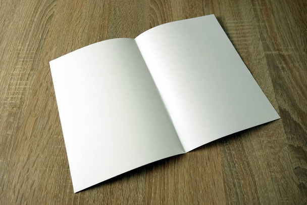 Libro o folleto en blanco sobre un escritorio de madera
 - Foto, Imagen