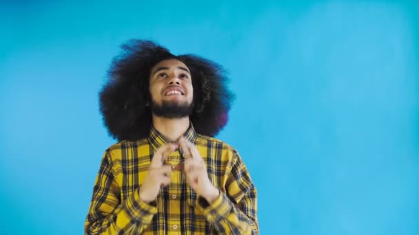 Portrait of praying african american guy keeping fingers crossed and screaming god please on Blue background. Concept of emotions - Footage, Video