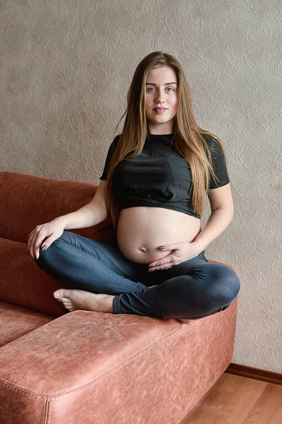 Молодая беременная женщина. Беременная красивая женщина позирует дома
. - Фото, изображение