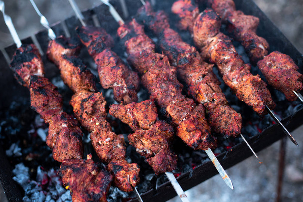 geroosterd vlees, Spiesjes met uien op spiesjes op de grill - Foto, afbeelding