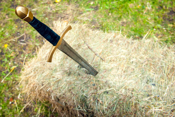 Средневековый меч застрял в стоге сена
 - Фото, изображение