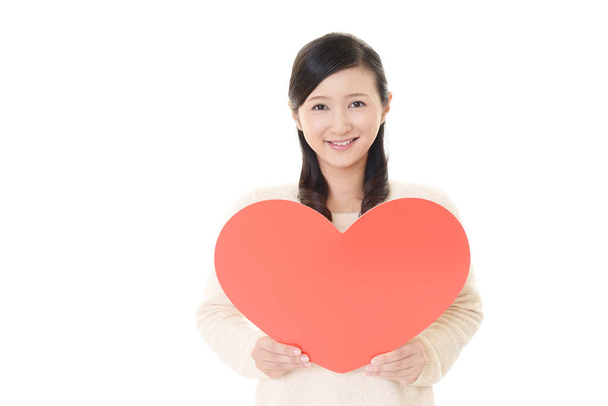 Usmívající se žena hospodářství červené srdce láskou symbolu - Fotografie, Obrázek