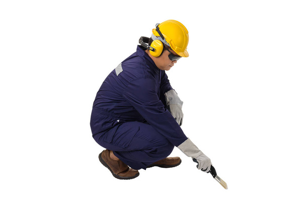 werknemer in Mechanic Jumpsuit Zitten en vasthouden van een verfborstel is - Foto, afbeelding