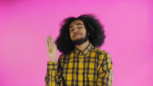 A fiatal afro-amerikai férfi csendet vagy bla bla gesztust mutat lila alapon. Az érzelmek fogalma - Felvétel, videó