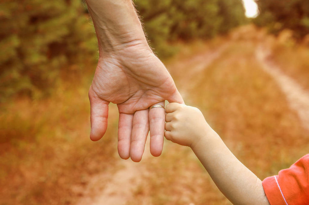 Stílusos kezében egy szülő és gyermek a természetben egy parkban vissza - Fotó, kép