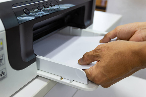 hand man estabelece o papel da impressora no escritório, conceito de negócio
 - Foto, Imagem