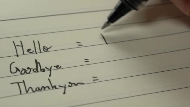 Französisch-Anfänger schreiben Wörter auf Französisch für Hausaufgaben auf einem Notizbuch Nahaufnahme - Filmmaterial, Video