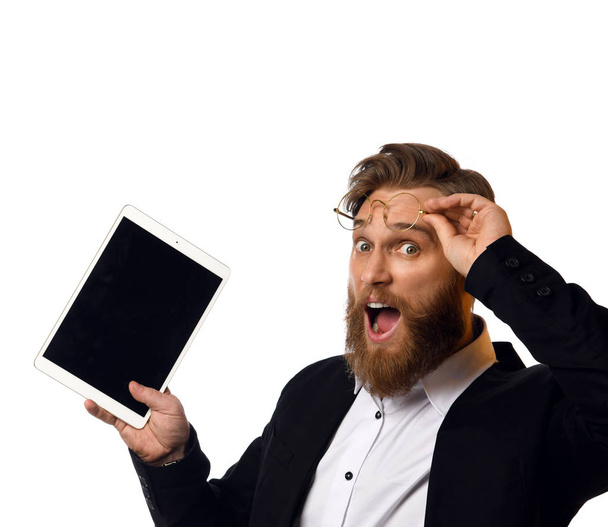 Inteligentny człowiek biznesu w czarnym garniturze i białej koszulce dokonać zakupu online za pomocą tabletu komputera w okularach - Zdjęcie, obraz