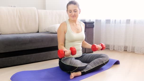 4k footage of beautiful young woman exercising at home with red dumbbells - Footage, Video