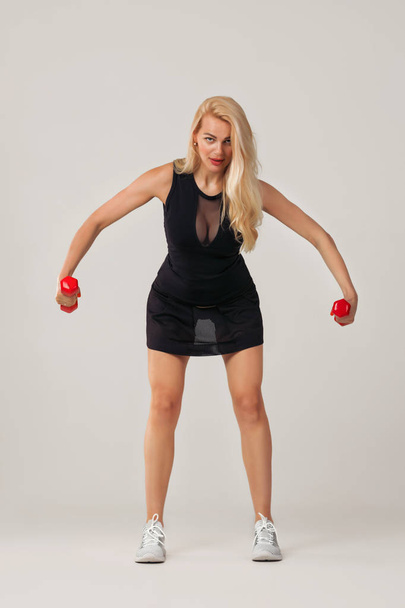 beautiful woman holding red dumbell - Photo, Image