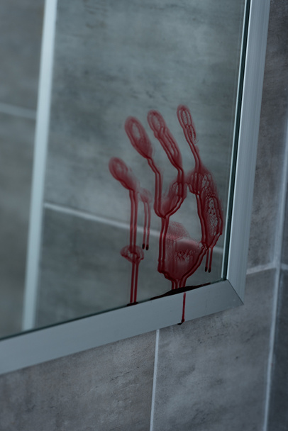 selective focus of bloody handprint on mirror in bathroom - Foto, imagen