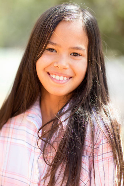 Portrait of a young asian girl smiling outside. - Foto, Bild
