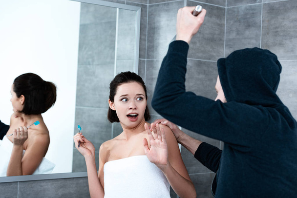 killer attacking woman with knife while she brushing teeth in bathroom - Фото, зображення