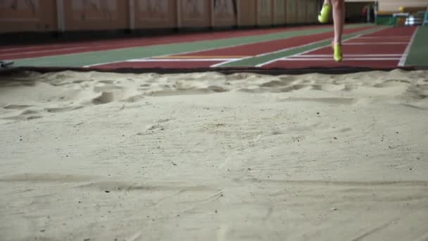 Meisje atleet het uitvoeren van lange sprong in sandbox - Video