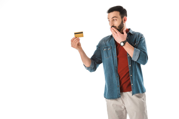 удивленный человек закрывая рот рукой, держа цифровые таблетки изолированы на белом
 - Фото, изображение