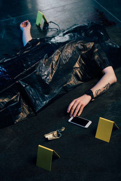 cadavere coperto con smartphone e banconote da un dollaro sulla scena del crimine
 - Foto, immagini