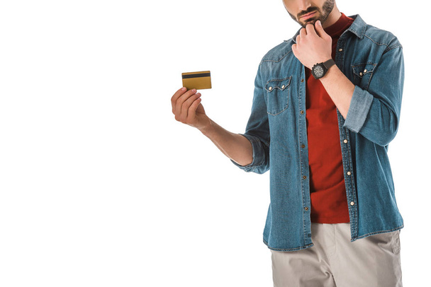 Erwachsener Mann im Jeanshemd hält Kreditkarte isoliert auf weißem Grund - Foto, Bild