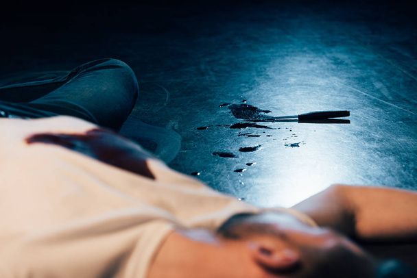 partial view of dead man on floor at crime scene - Foto, Imagen