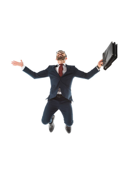opgewonden zakenman met aktetas glimlachend en springen geïsoleerd op wit - Foto, afbeelding