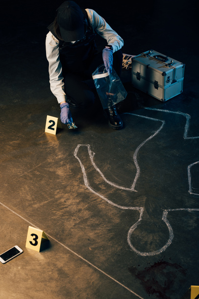 investigator in uniform gathering evidences at crime scene - Photo, Image