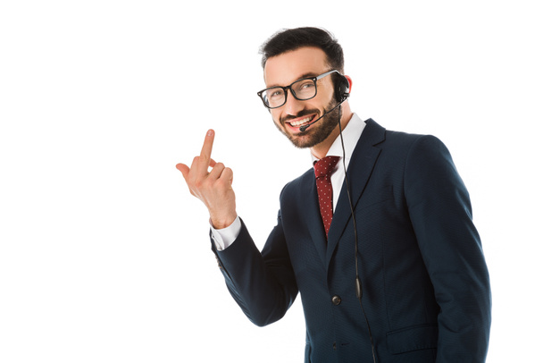 cheerful handsome call center operator in headset showing middle finger and looking at camera isolated on white - Photo, Image