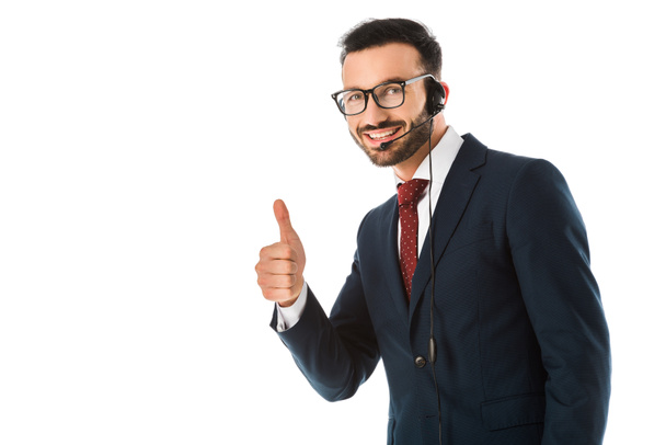 happy call center operator in headset showing thumb up and smiling at camera isolated on white - Фото, зображення