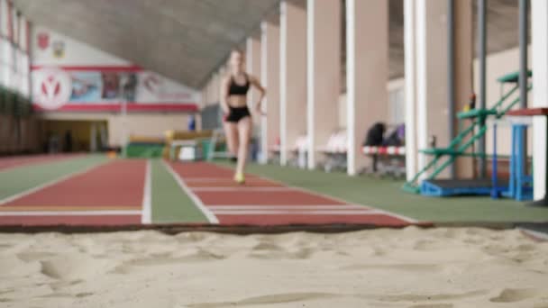 Meisje atleet het uitvoeren van lange sprong in sandbox - Video