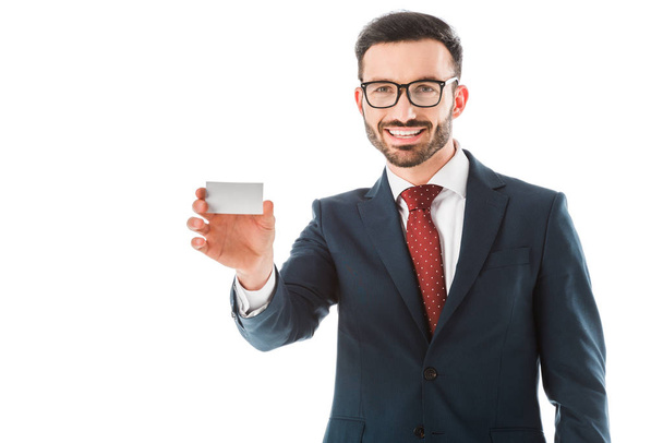 cheerful businessman holding blank business card and looking at camera isolated on white - Fotografie, Obrázek