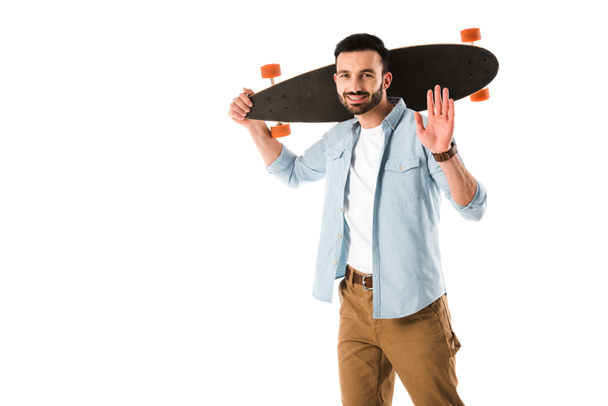 cheerful man with longboard looking at camera and showing hello gesture isolated on white - Фото, изображение