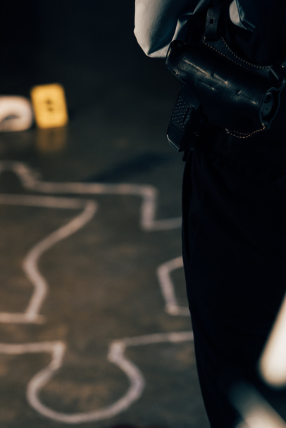 cropped view of investigator with gun at crime scene - Φωτογραφία, εικόνα