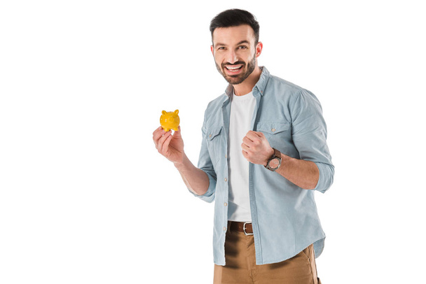 happy handsome man holding piggy bank and showing yes gesture isolated on white - Fotografie, Obrázek