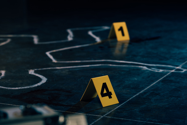 selective focus of chalk outline and evidence markers at crime scene - Φωτογραφία, εικόνα
