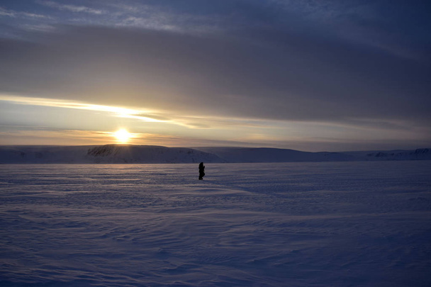 lonely man in the Arctic desert at sunset - Fotó, kép