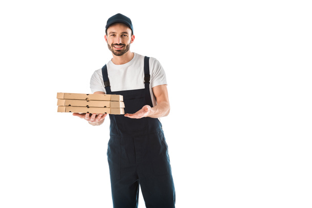 cheerful delivery man holding pizza boxes and smiling at camera isolated on white - Foto, Imagen